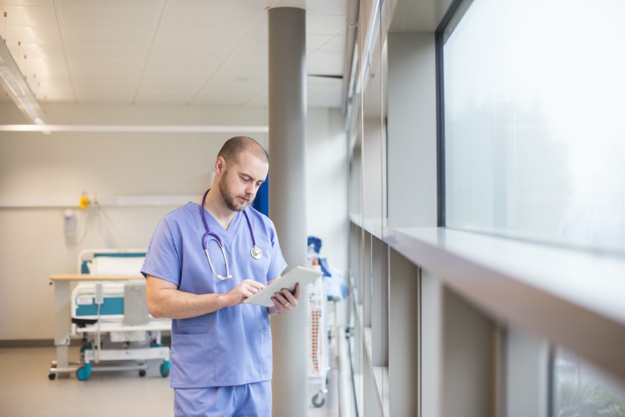 Doctor looking through notes on a tablet.