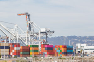 Shipping port featuring cranes and colorful shipping containers.